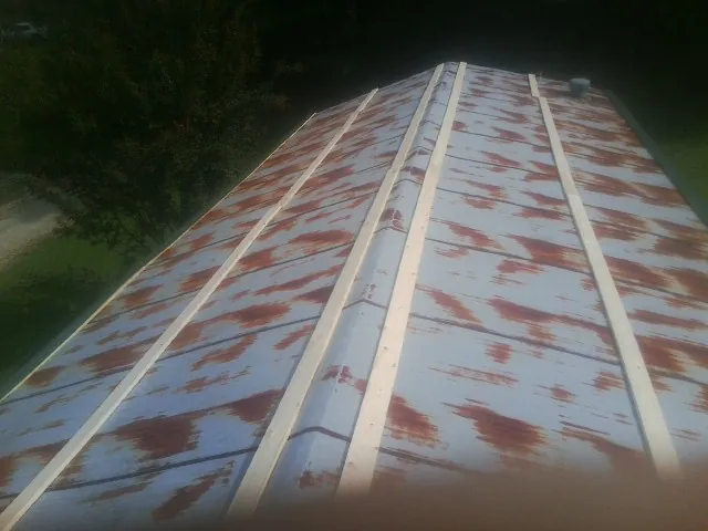 Rusted metal roof panels with new wood purlins before replacement — Storm Damage Roof Repair in Sealy by Roofing Brothers