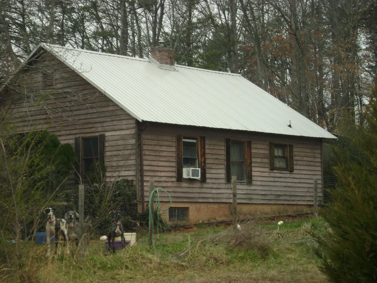 White metal roof on an old wood sided farmhouse, from a Metal Roof Installation job in Sealy